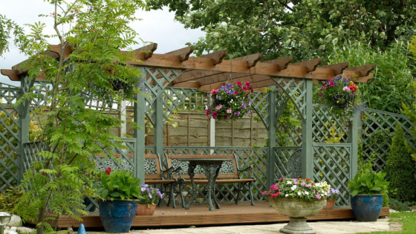 Taman dengan gazebo dan tanaman rambat di atap